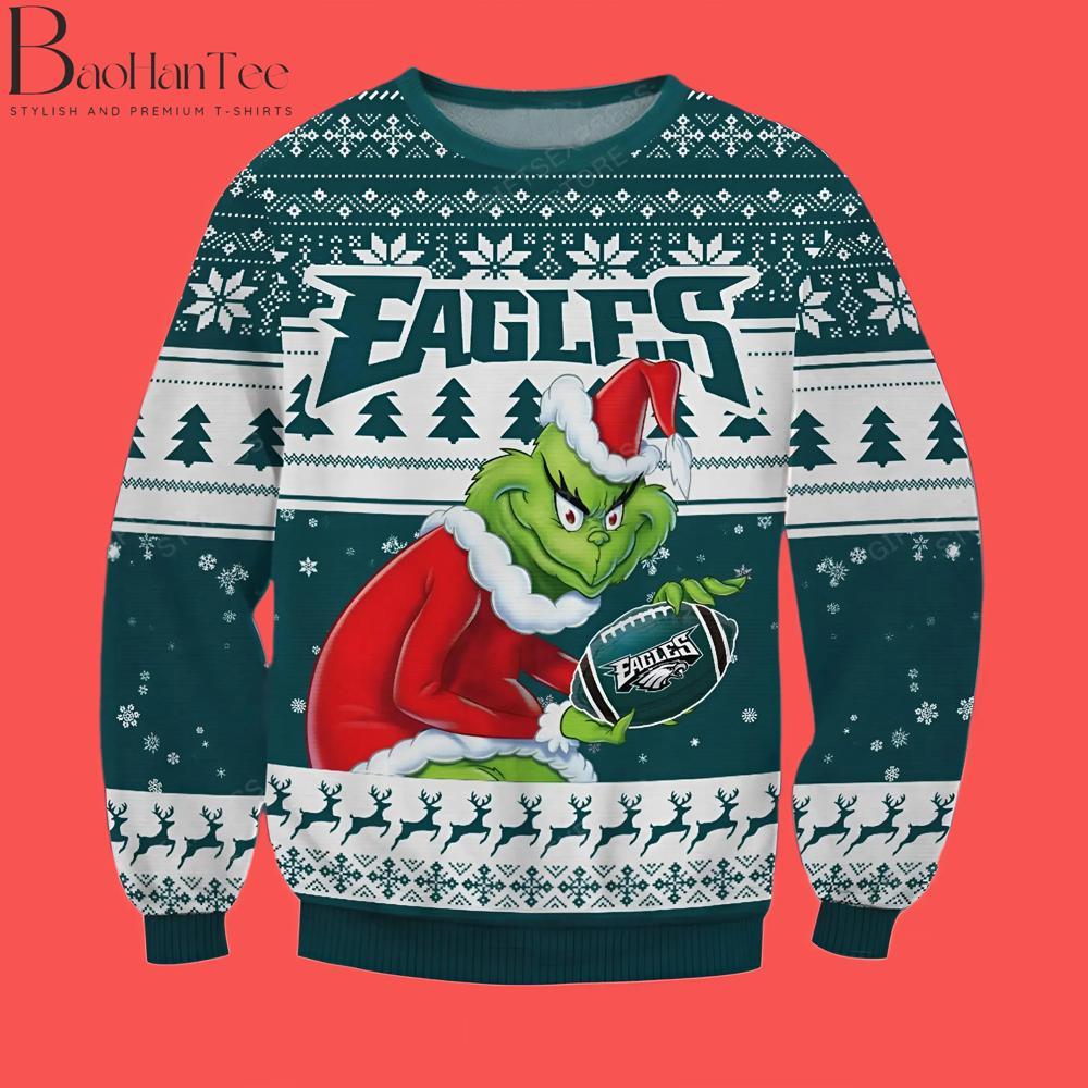 Perfect for Philadelphia Eagles fans, this sweater shows the Grinch holding an Eagles football, combining sports fandom with holiday fun. It’s a great choice for anyone who wants to celebrate both Christmas and football season.