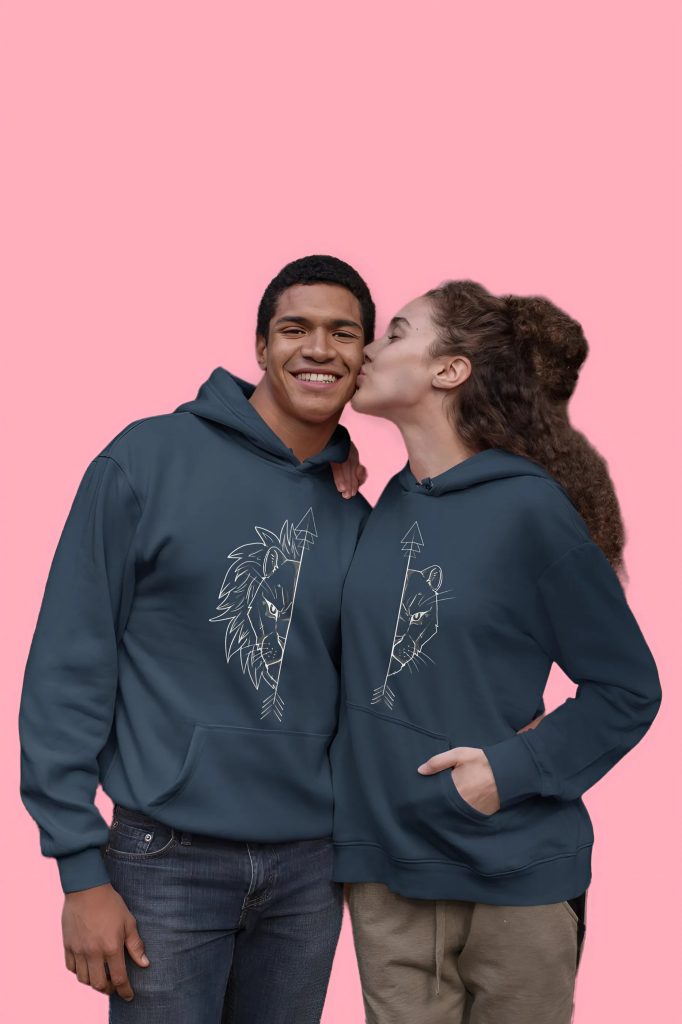 Couple wearing navy blue matching lion hoodies, smiling and embracing.